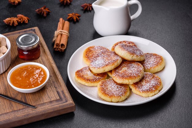 Hüttenkäse-Pfannkuchen mit Hafer-Syrniki auf schwarzem rustikalem Hintergrund