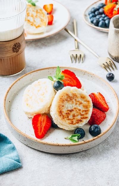 Hüttenkäse-Pfannkuchen Syrniki mit frischen Beeren