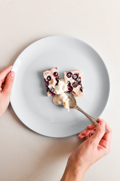 Hüttenkäsekuchen mit Beeren. mit einem Löffel essen. Sicht von oben.