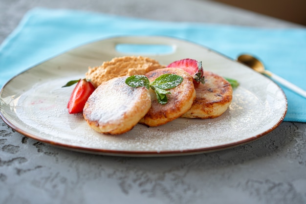 Hüttenkäsepfannkuchen mit Erdbeere und Zuckerpulver