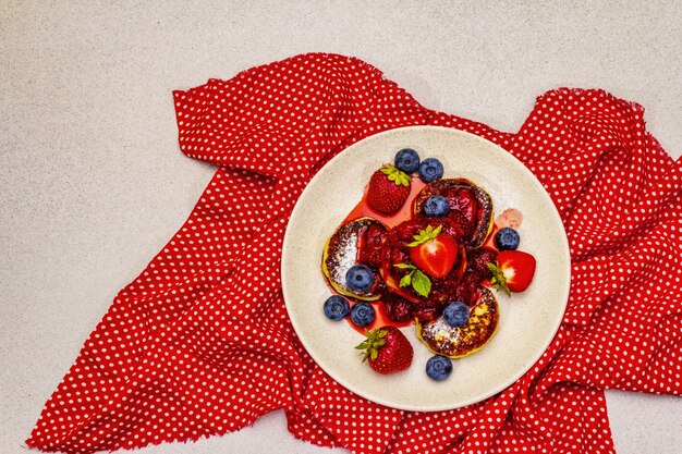 Hüttenkäsepfannkuchen mit frischen Beeren und Erdbeersauce