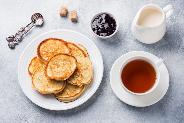 Hüttenkäsepfannkuchen mit Marmelade und Tee. Konzept gesundes Frühstück.