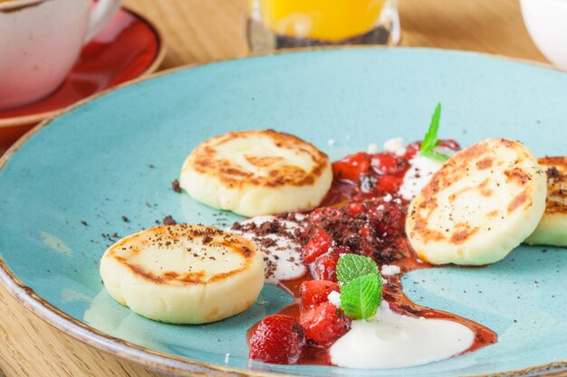 Hüttenkäsepfannkuchen mit saurer Sahne und Himbeermarmelade