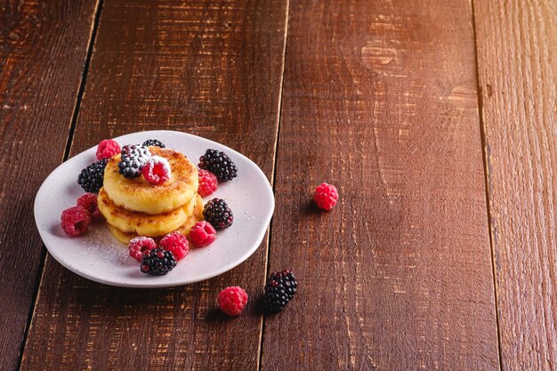 Hüttenkäsepfannkuchen und Puderzucker mit Beeren