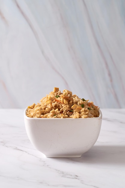 Huevo asiático chino y arroz frito con verduras en una mesa blanca