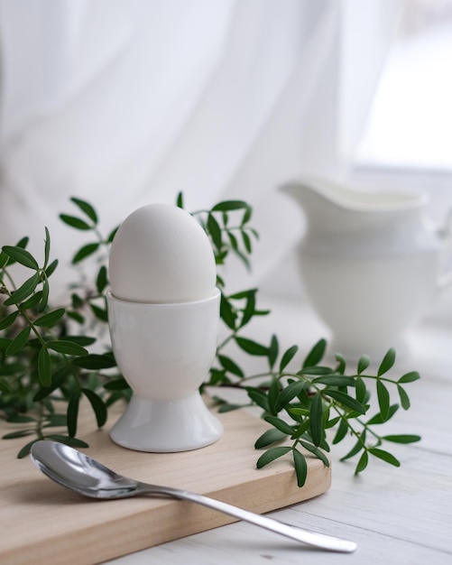 Huevo blanco recién hervido en una tabla de madera Desayuno saludable Concepto matutino