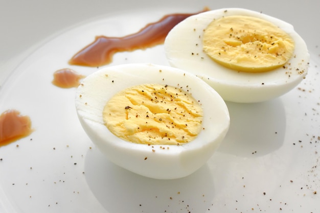 Huevo cocido con pimienta molida en un plato blanco.