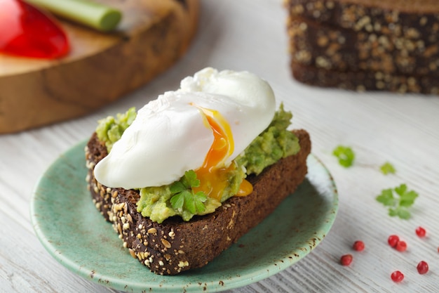 Huevo escalfado sobre tostadas integrales con aguacate