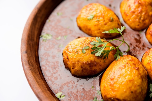 Foto huevo frito al curry o anda masala servido en un bol