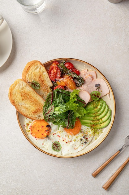 Foto huevo frito desayuno con ensalada y aguacate