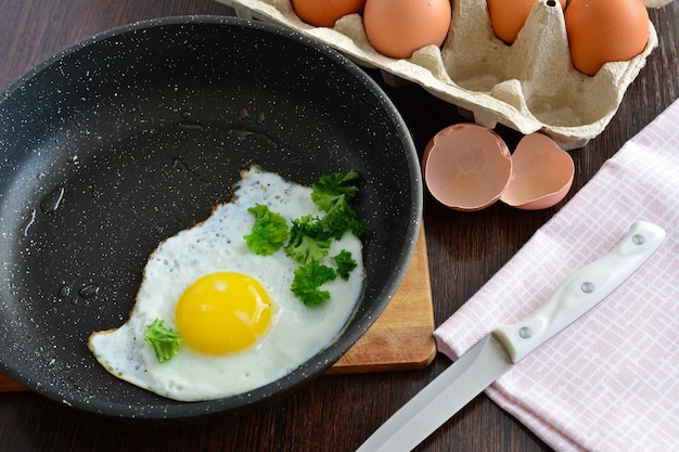 huevo frito en sartén con bandeja de huevos