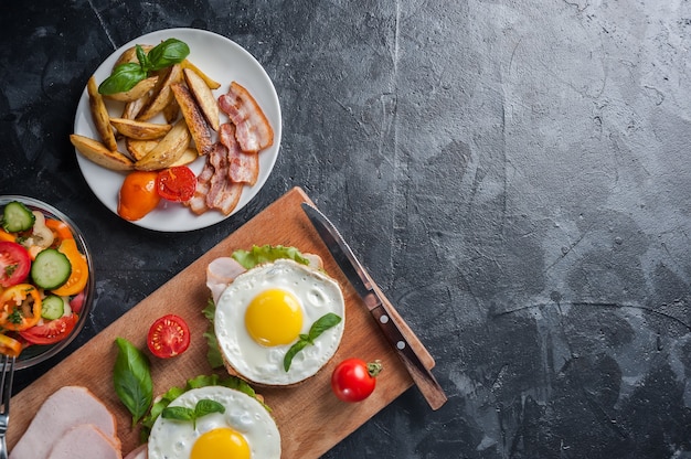 Huevo frito y tocino en un plato, café en una mesa rústica de madera, endecha plana