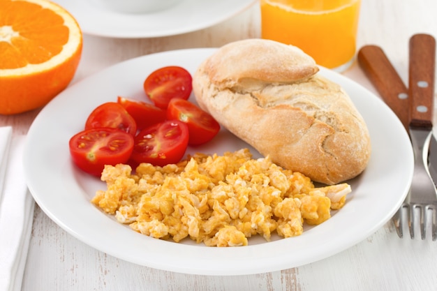 Huevo frito con tomate, pan y zumo de naranja.