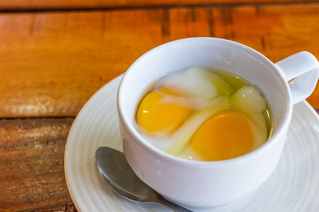 Huevo hervido suave en taza blanca con comida de la mañana de cuchara