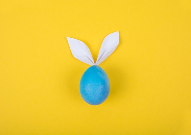 Huevo con orejas de papel en forma de conejito de Pascua. Feliz Pascua Concepto Tarjeta Postaer Antecedentes. Foto de estudio