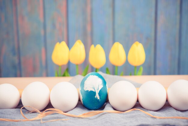 Huevo de Pascua azul orgánico en medio de huevos de color blanco espera para pintar