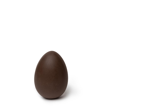 Huevo de pascua de chocolate entero aislado sobre fondo blanco espacio de copia minimalismo Golosina de chocolate para niños Concepto de Pascua