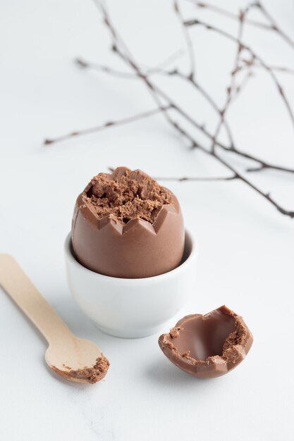 Huevo de pascua de chocolate en un portahuevos blanco