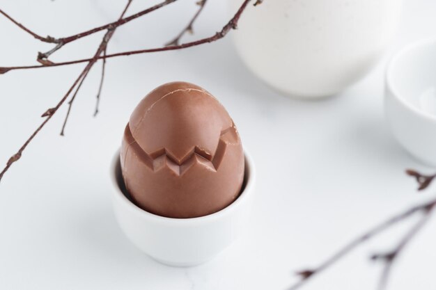 Huevo de pascua de chocolate en un portahuevos blanco