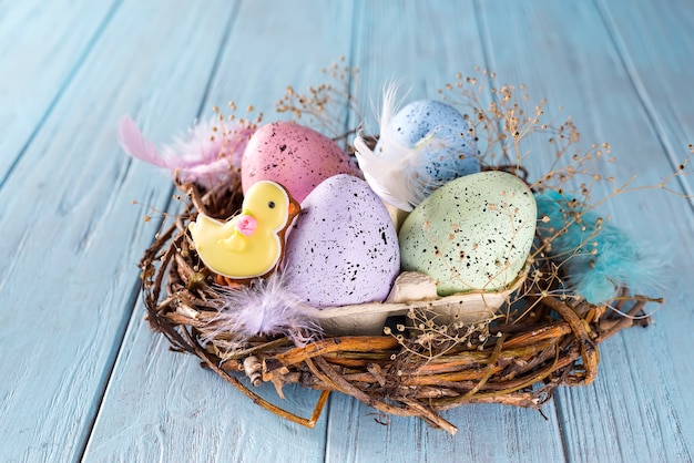 Huevo de Pascua colorido en el nido sobre fondo de madera