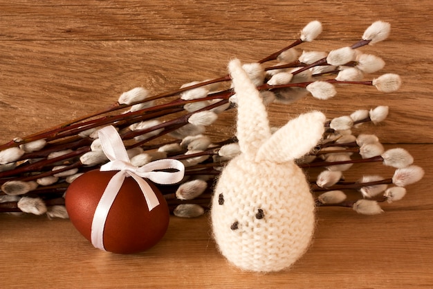 Foto huevo de pascua, conejo y amentos sobre un fondo de madera