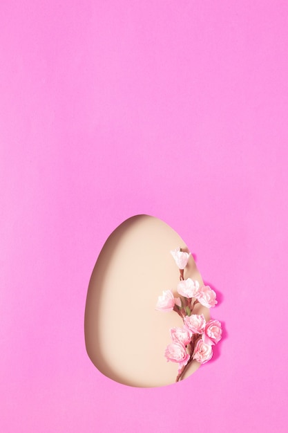 Huevo de Pascua cortado en papel con rama de flor de cerezo Copie el espacio para saludar con el día de Pascua Diseño minimalista