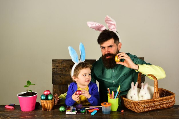 Huevo de pascua decorando familia feliz padre e hijo pintando huevos de pascua