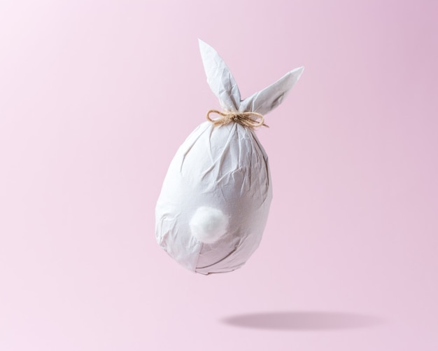 Huevo de Pascua envuelto en un papel con forma de conejito.