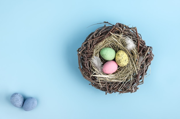 El huevo de pascua es una canasta aislada en azul