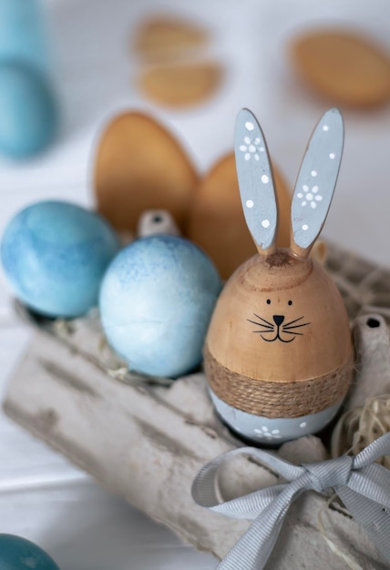 Un huevo de Pascua de madera con cara de conejo.