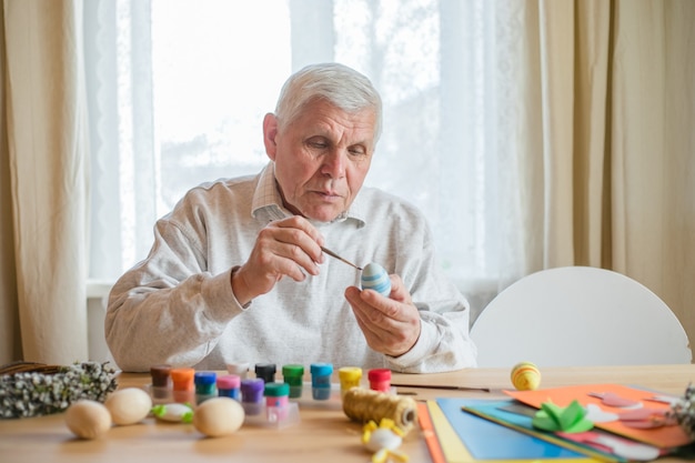 Huevo de Pascua pintado a anciano jubilado emocionado. Huevos de pascua artesanales de bricolaje