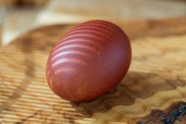 Huevo de Pascua teñido multicolor con sombras Huevo de Pascua marrón sobre una tabla de madera closeup