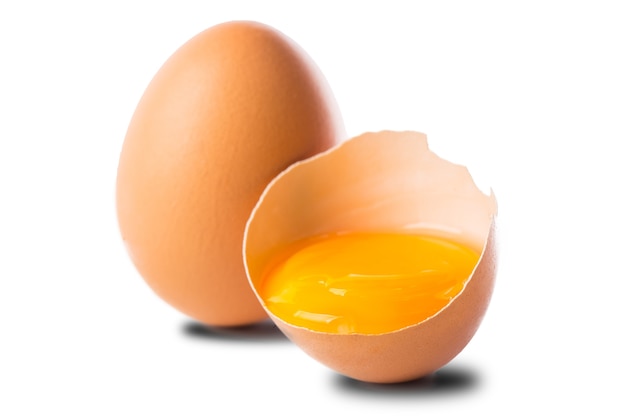 Huevo roto aislado colocado sobre el fondo blanco.