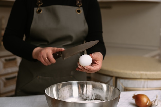 Foto huevo roto con yema en un bol con harina. la receta de la masa.