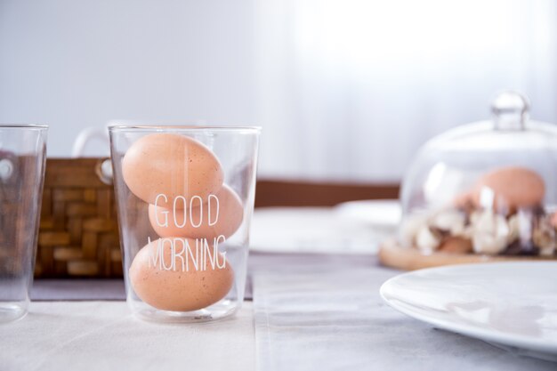 huevo en vaso con buenos días texto sobre la mesa en la cocina