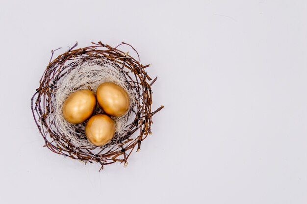 Huevos adornados de oro de Pascua en el fondo blanco.