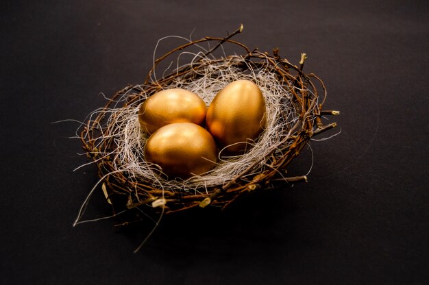 Huevos adornados de oro de Pascua en fondo oscuro.