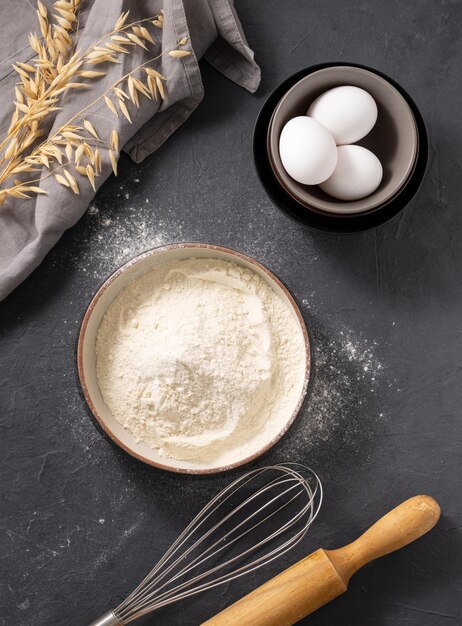 Huevos de avena y rodillo sobre un fondo oscuro Ingredientes de horneado orgánicos Concepto de comida casera y saludable