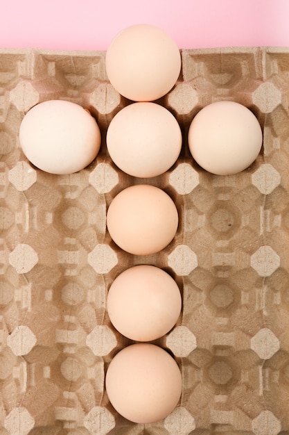 Huevos en una bandeja en forma de cruz. Tendencia minimalista, vista superior. Bandeja de huevos. Concepto de pascua.