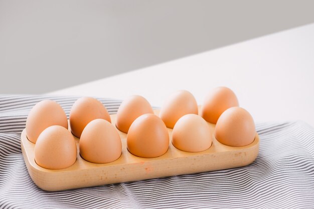 Huevos en una bandeja de madera listos para cocinar