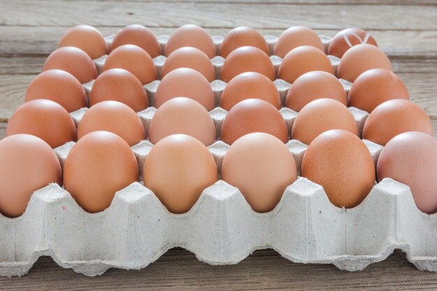 Huevos en una bandeja de papel sobre un fondo de madera