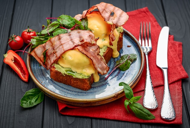 Huevos Benedict- tostados, tocino, huevos escalfados y deliciosa salsa holandesa con mantequilla. Un restaurante