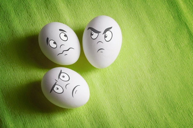 Huevos blancos con caras emocionales cómicas