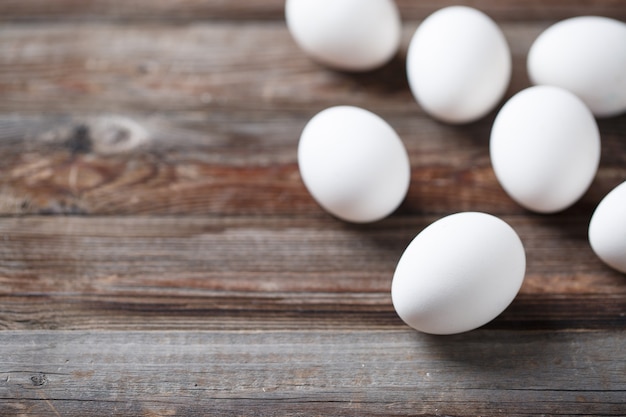 Huevos blancos en la mesa de madera vieja