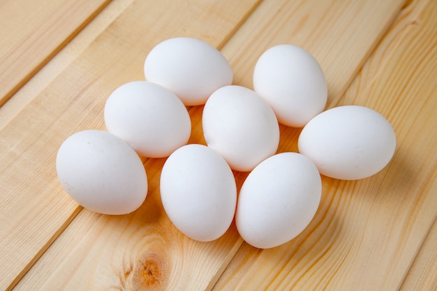 Huevos blancos en una mesa de madera