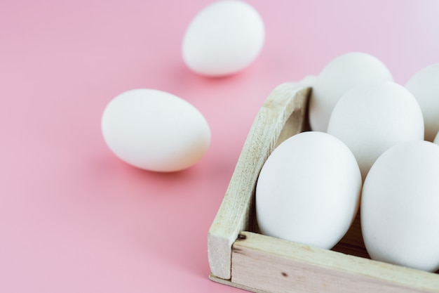 Huevos blancos sobre fondo rosa para cocinar alimentos