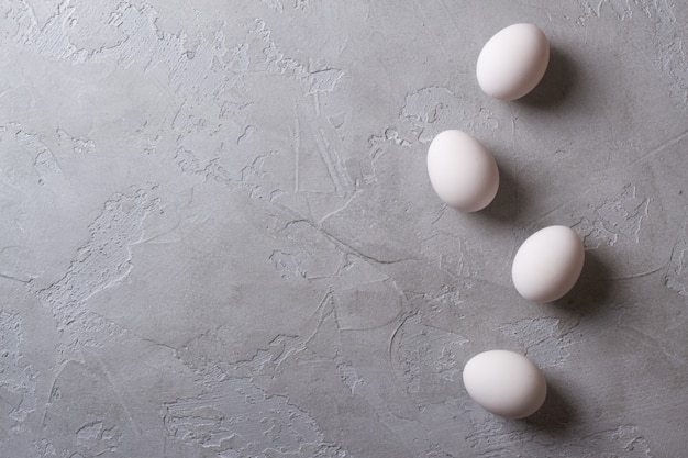 Foto huevos blancos sobre una mesa de hormigón gris