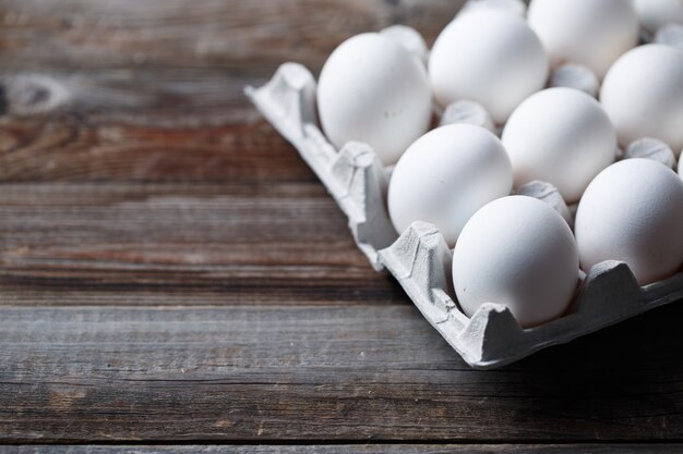 Huevos blancos sobre una mesa de madera rústica