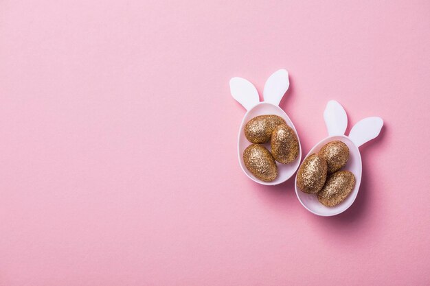 Huevos de brillo dorado en forma de huevo de conejito de pascua blanco con orejas