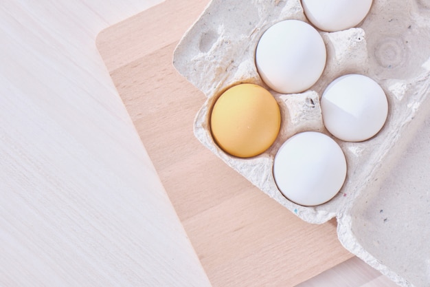 huevos en una caja de cartón y una mesa de madera